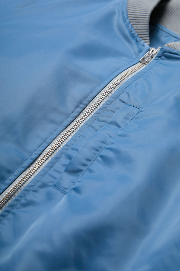 The Strata Bomber Jacket is a lightweight nylon jacket in Blue with double opening YKK hardware.