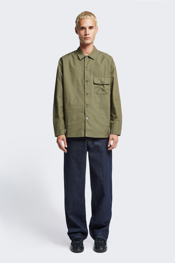 The Territory Overshirt Olive Khaki is a military-inspired overshirt made from mid-weight cotton drill. This button up shirt  has shaped cuffs with button closure, 3D patch pocket, topstitched placket and side pocket, and a rounded hemline.