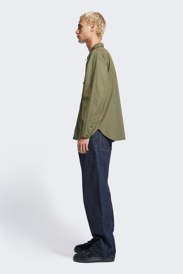 Side profile of the Territory Overshirt, a long sleeve overshirt with shaped cuffs with button closure and rounded hemline. Made from a mid-weight cotton drill in Olive Khaki. 