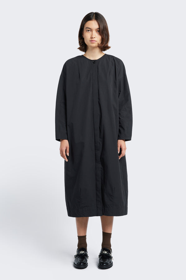 The Agora Dress Black, a long sleeve, slightly boxy style with round neckline, concealed button-through placket at the front and darted detailing.