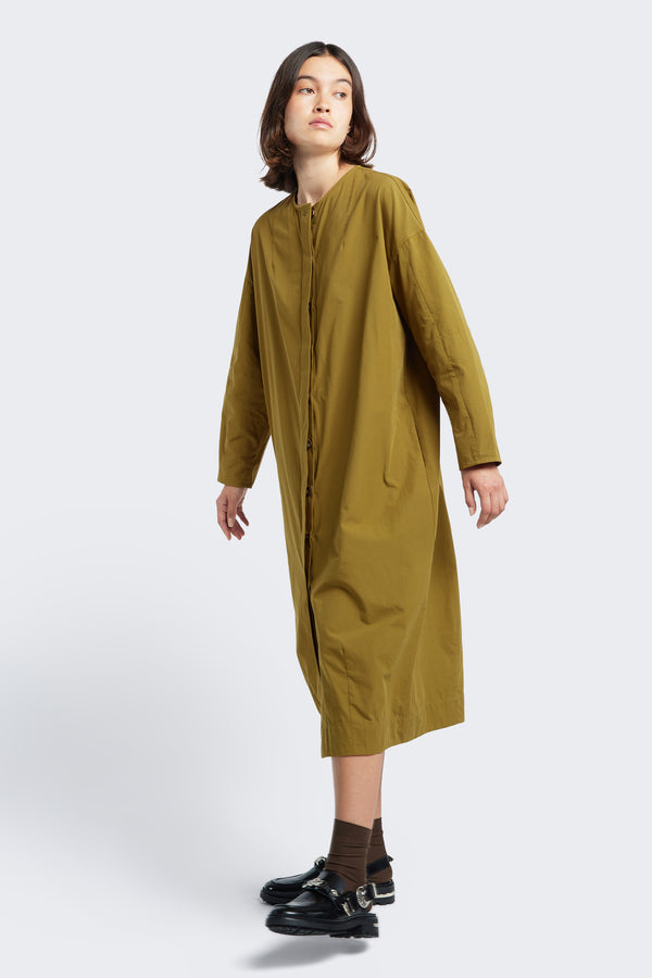 Model wearing the Agora Dress Moss Green, a slightly boxy oversized style made from 100% cotton.