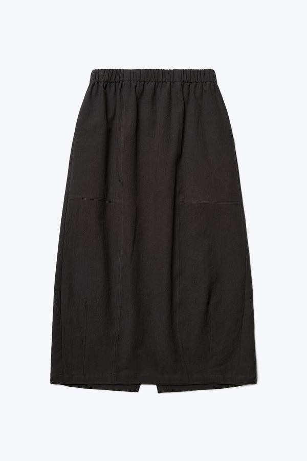 The front of the Anima Skirt in Black, a long, straight style skirt with elasticated waistline, darted panels and straight hem. Crafted in textural cotton. 