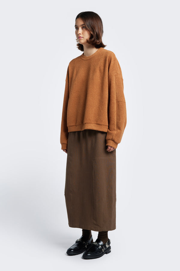 The straight style Anima Skirt Brown styled with the Respite Sweater Rusty Brown.