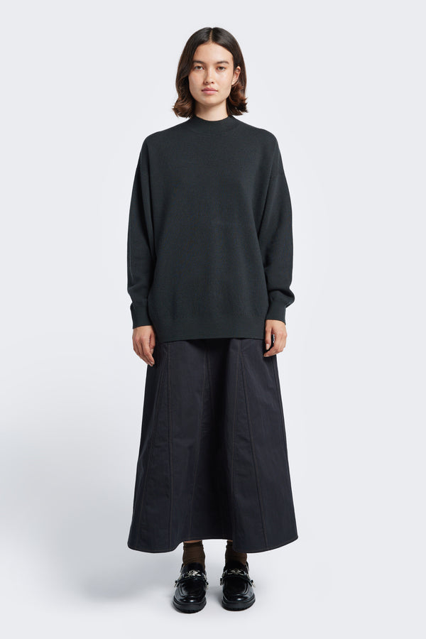 The Buro Knit Sweater Charcoal a mock neck merino sweater crafted in a milano knit structure that finishes just below the hip with a 1x1 rib hemline.