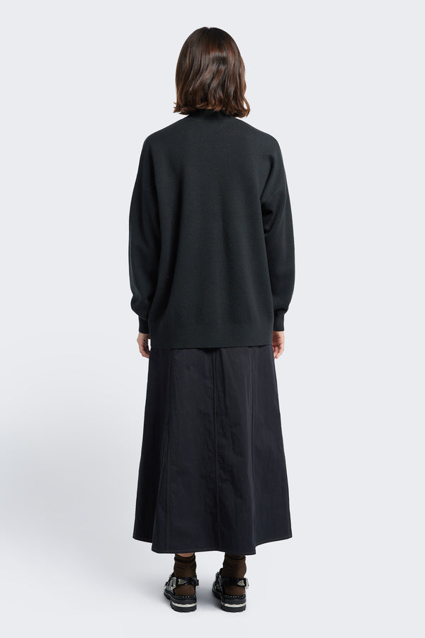 The back of the Buro Knit Sweater Charcoal, a mock neck merino sweater crafted in a milano knit structure with  dropped shoulders and finishing just below the hips with a 1x1 rib hemline.