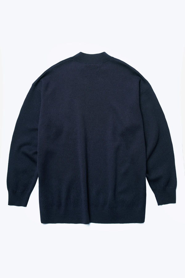 The back of the Buro Knit Sweater Ink is a mock neck merino sweater crafted in 100% Merino wool and accented with a dropped shoulder and long line of the body, finishing just below the hips with a 1x1 rib hemline. 