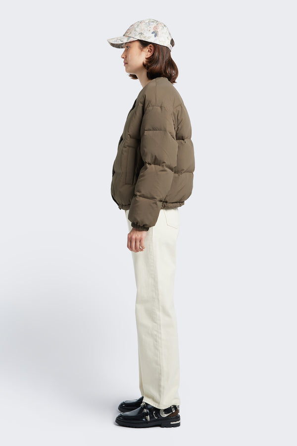 Side profile of the Daybreak Quilted Jacket Brown made from 100% Recycled Nylon, Lining 100% Recycled Nylon, Fill 100% Post Consumer Down Fill. This puffer jacket features elastic side pulls to give shape.