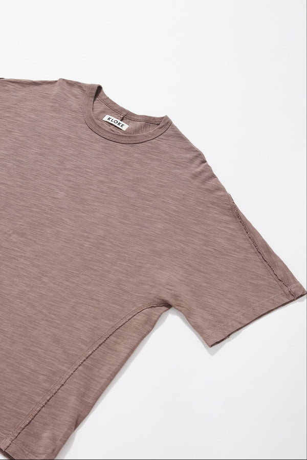 Close-up of the flat-lock seam detailing creating the twisted sleeve on the brown Overdyed Declare Tee.