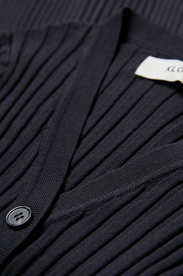 Close up of the rib texture detail of the Delay Short Sleeve Knit in deep ink made from 80% Viscose, 20% Nylon.