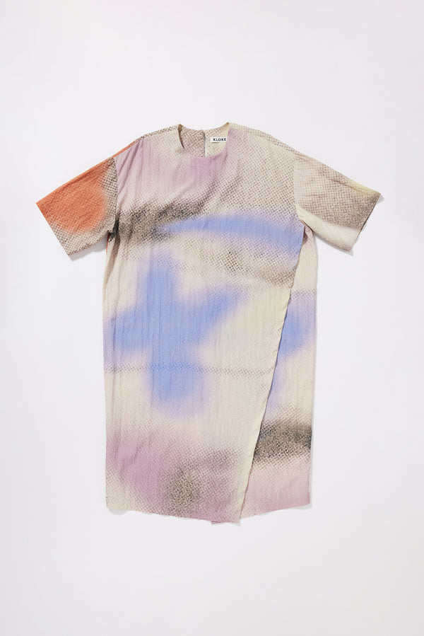 Eon Dress in Aion Print front view showing fluid midi silhouette, double-layered asymmetric split front and fragmented mauve, blue and orange deity print