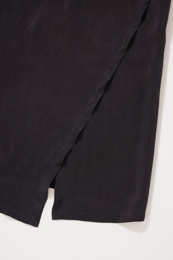 Close up fabric shot of the Eon Dress in vintage black cupro showing double-layered asymmetric split front.