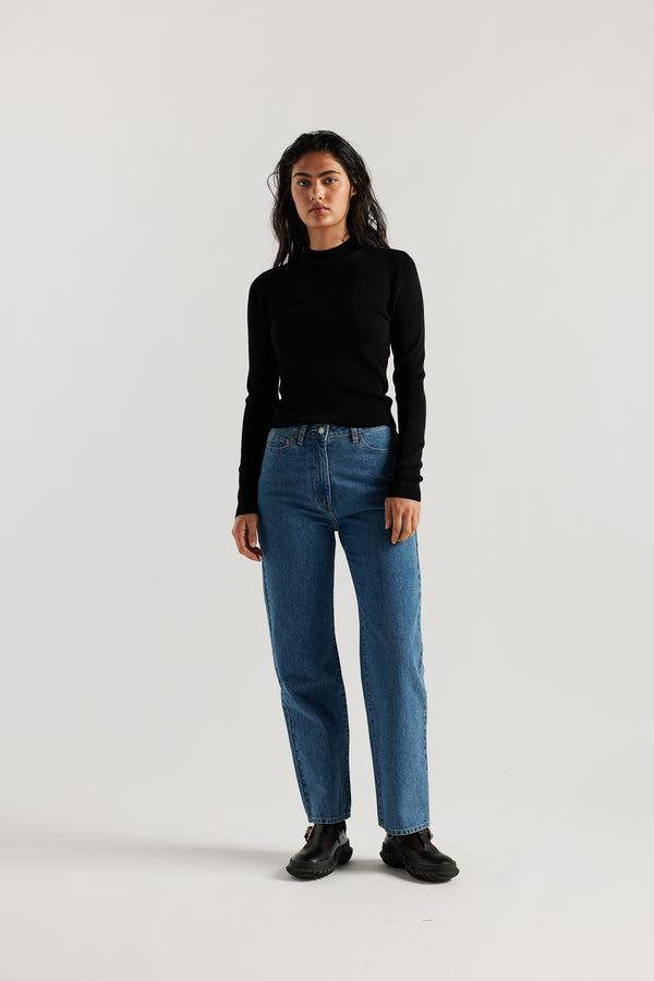 Model wearing straight-leg Evade jeans in mid blue premium Japanese denim with slightly higher rise and flattering fit