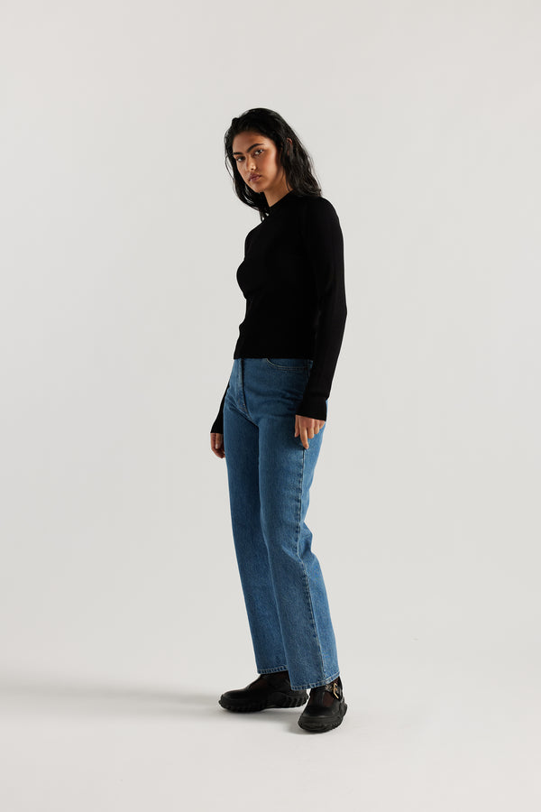 Model wearing straight-leg Evade jeans in mid blue premium Japanese denim with slightly higher rise and flattering fit