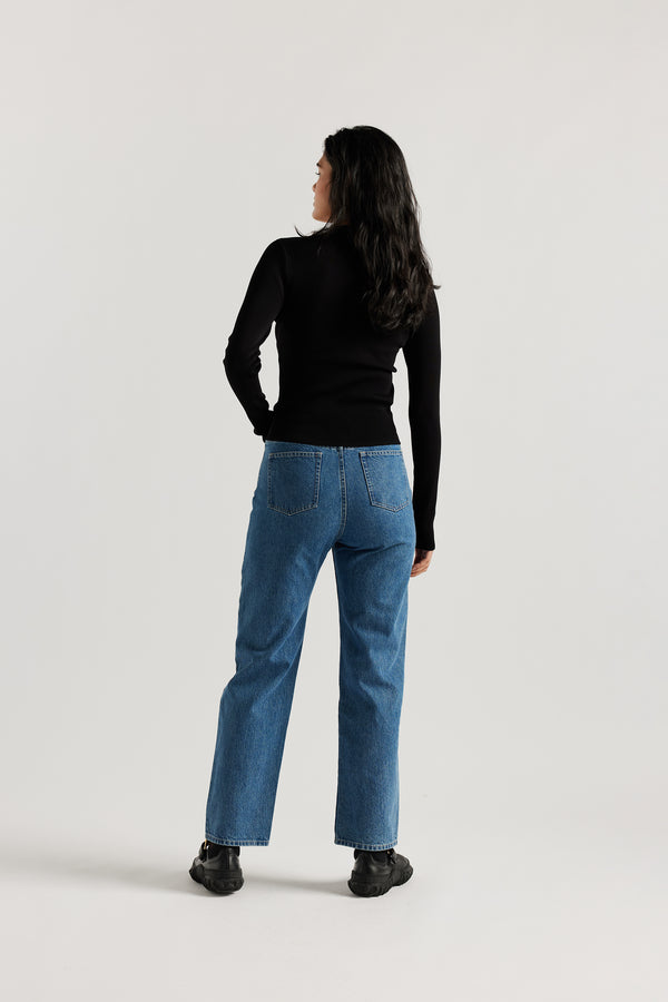 Model wearing straight-leg Evade jeans in mid blue premium Japanese denim with slightly higher rise and flattering fit