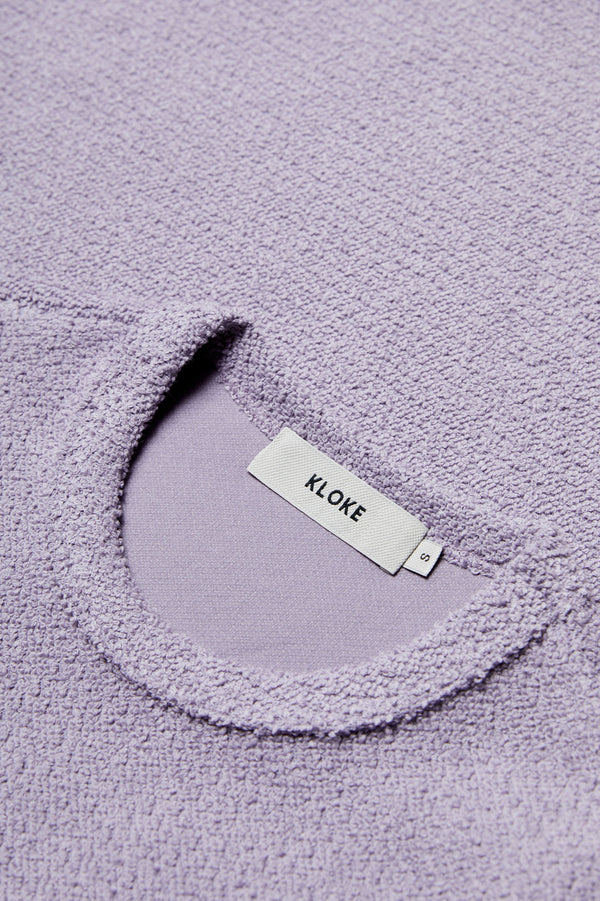 Close up of the thick jersey fabric on the Exodus Tee Lilac Purple. This thick jersey has a textured loop weave for a brushed finish.