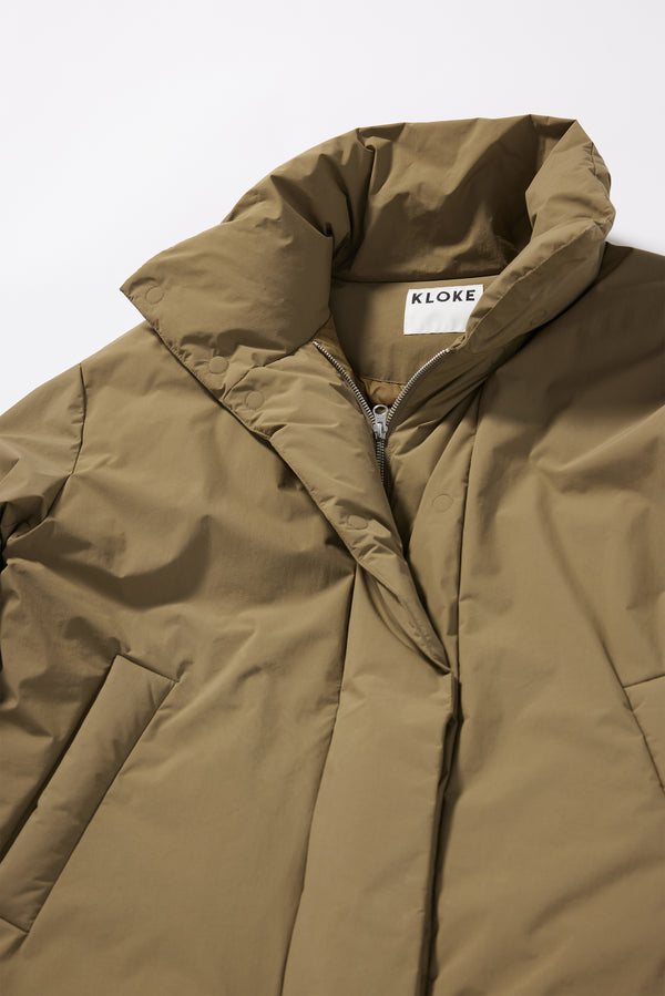 Close-up of the down-filled high collar and centre-front zip with magnetic fastenings on the Olive Floating Puffa Coat