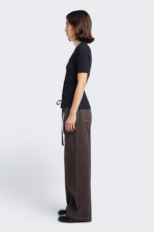 Side profile of the Found Tie Front Pant Brown, complete with contrast topstitch, patch pockets at the rear, and diagonal seam pockets at the front.