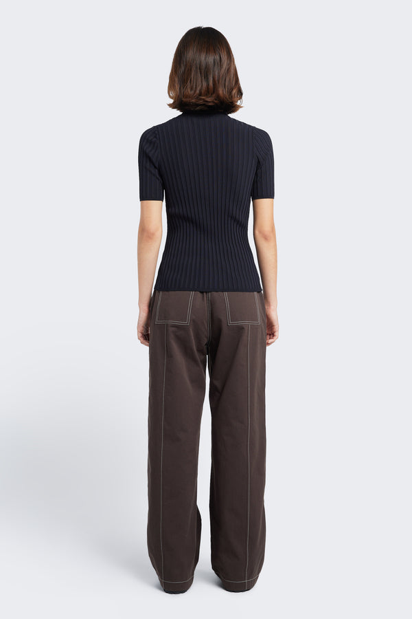 The back of the model wearing the Found Tie Front Pant Brown with white Stitch. These are a relaxed, straight-leg pant with patch pockets at the rear and crafted from durable cotton.