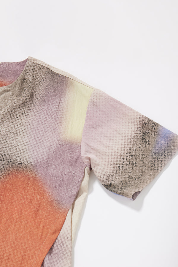 Close-up of the Aion Print on the Glimmer Top showing fragmented asymmetric depiction of the deity of time in distorted mauve, blue and orange