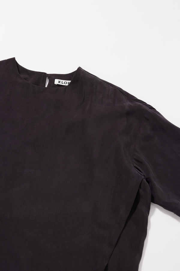 Close-up of the washed vintage black cupro fabric showing its soft texture and fluid drape.
