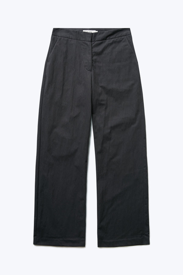 The front of the Grace Pant, a slim, straight leg pant with mid-rise waistline. Crafted from a transcendent linen-cotton blend in black and finished with gently angled side pockets. 