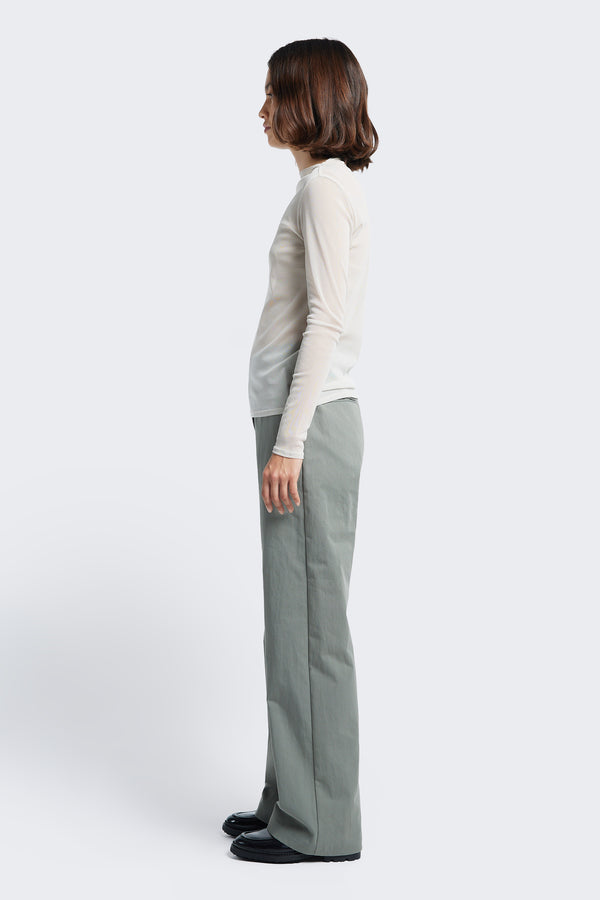 Side profile of the Grace Pant Grey, a slim, straight leg pant with a mid-rise waistline. Crafted from a linen-cotton blend and finished with angled side pockets.