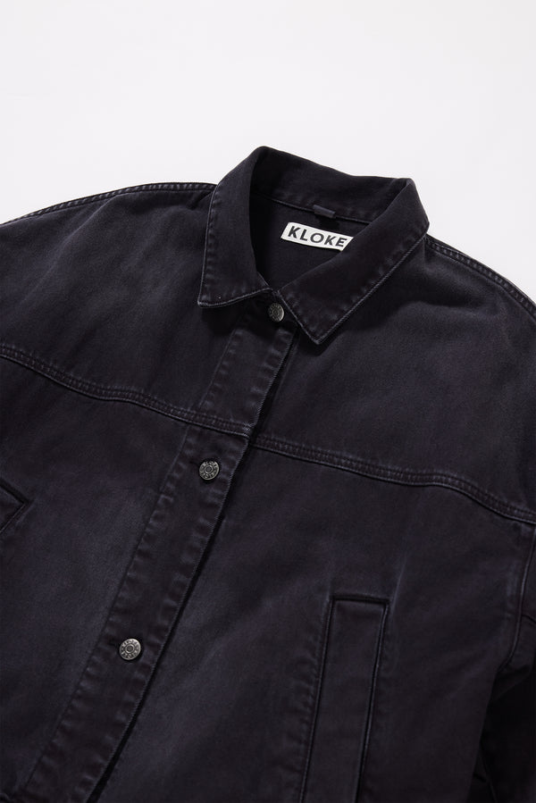 Close-up of over-dyed and stone-washed Black fade denim showing texture and colour variation.