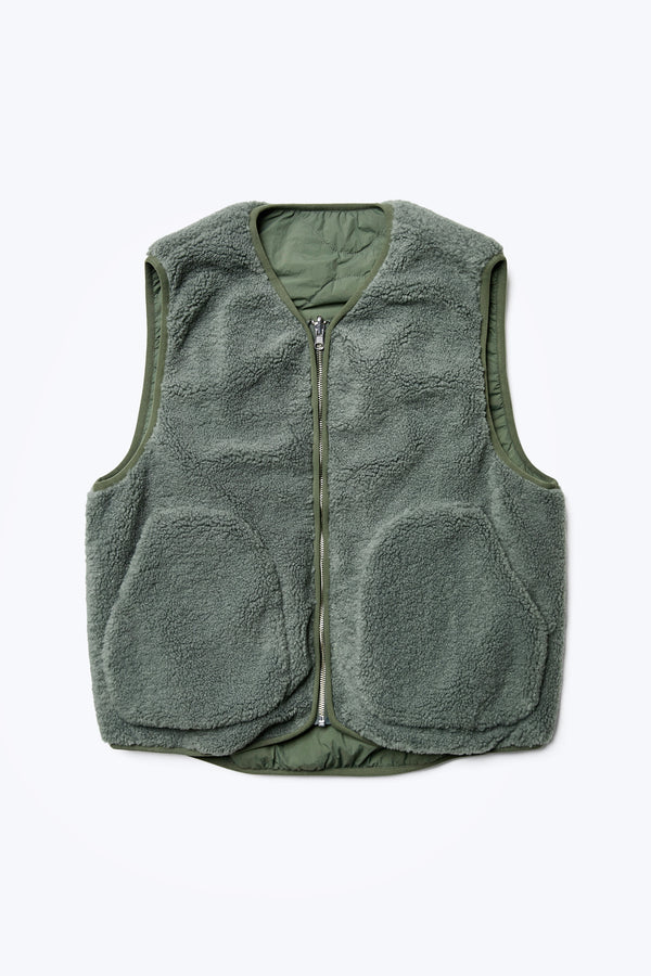 The Hearth Shearling Reversible Vest with a warming faux shearling fabrication in Petrol Green with a centre front zip closure. Available in five sizes.