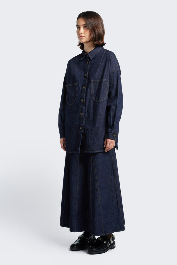 The Idle Denim Skirt Indigo styled with the Recess Denim Shirt. The Idle skirt is a full godet style enhanced by contrast stitch details. This skirt features in seam side pockets and a centre back zip closure.