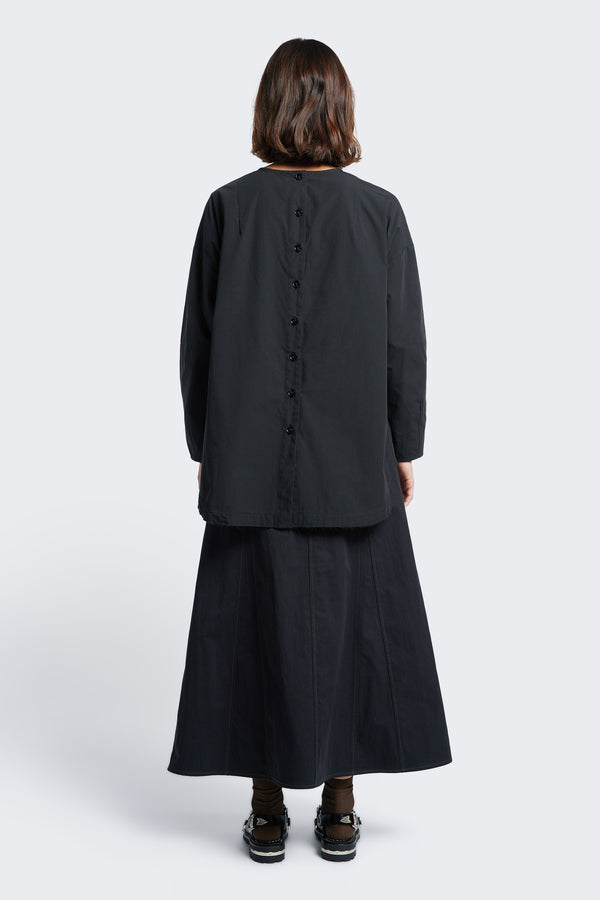 The back of the Idle Skirt Black,  a full godet style skirt with contrast stitch details and centre back zip closure.