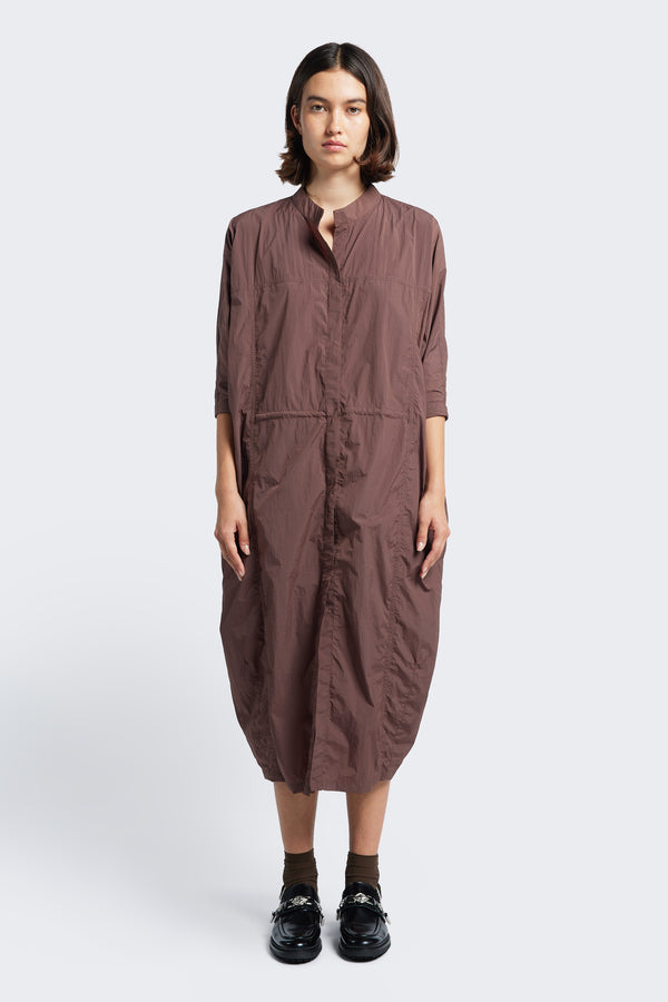 The Infra Dress Cocoa is a lightweight dress featuring seam details, a round neckline, dropped shoulders and pull ties at waist to adjust the fit to your liking.