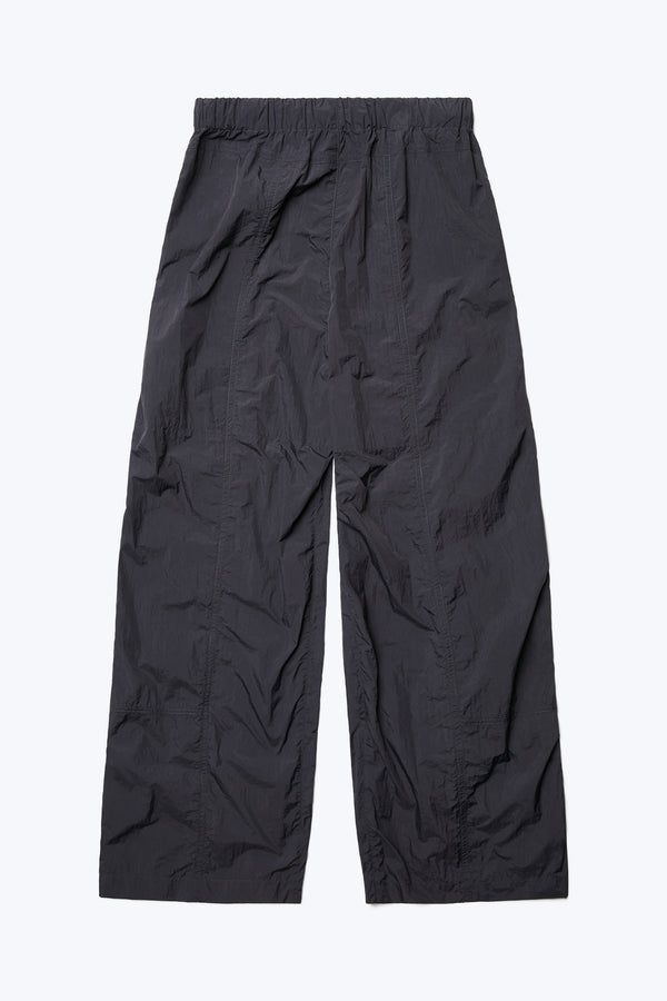 The back of the Inland Pant, a loose fitting pant featuring seam detail running down the front of the leg for texture and an elasticated waistband. Made from 100% Nylon in Black.