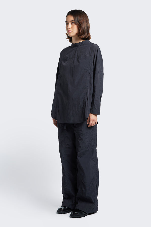 The Inland Pant Black styled with the Waking Blouse Black. This parachute style pant is a light, loose fit pant featuring seam detail running down the front of the leg for texture. 