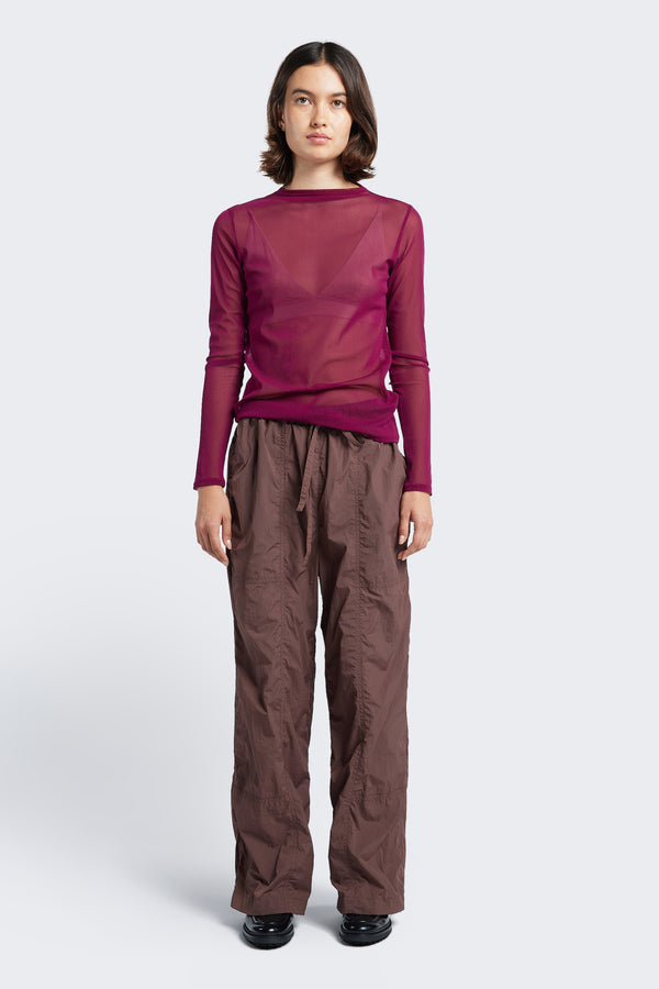 The Inland Pant Cocoa styled with the Exist Mesh Top Magenta. A parachute style pant that is light and loose fit. Features seam detail running down the front of the leg for texture. 