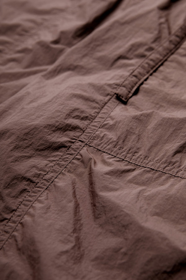 Close up of the Inland Pant Cocoa Brown made from 100% Nylon and featuring seam detail running down the front of the leg for texture. 