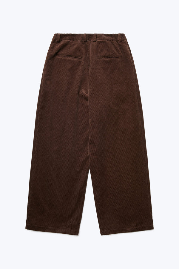 The back of the Interim Pant Dark Brown, a semi-tailored cord pant with a loose fit. Featuring two button-closing back pockets to keep valuables safe.