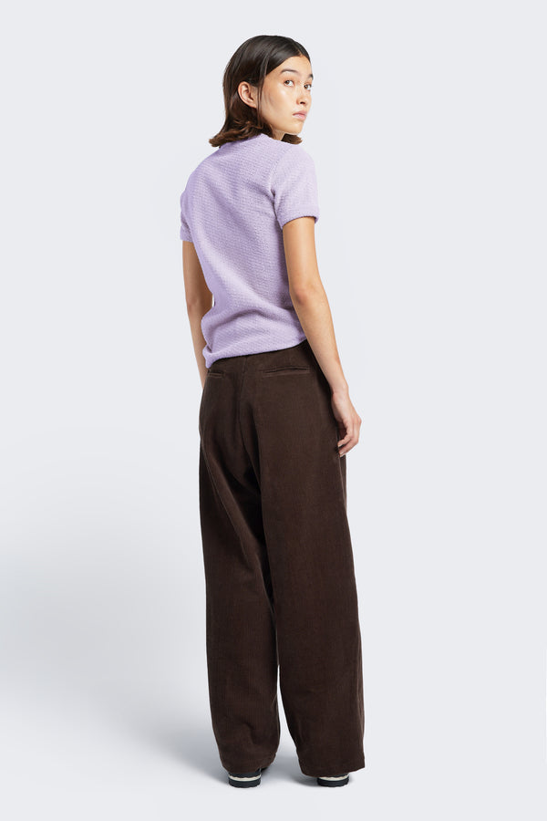 The back of Interim Pant Dark Brown, a semi-tailored cord pant two button-closing back pockets to keep valuables safe. 