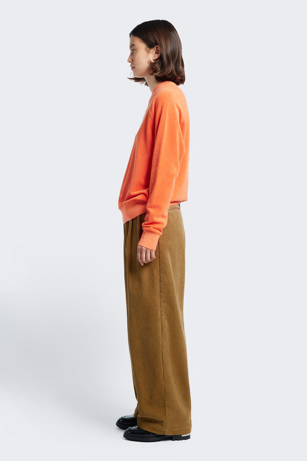 Side profile of the Interim Cord Pant Golden Tan, a semi-tailored pant with a generous and flattering double-pleated fit.