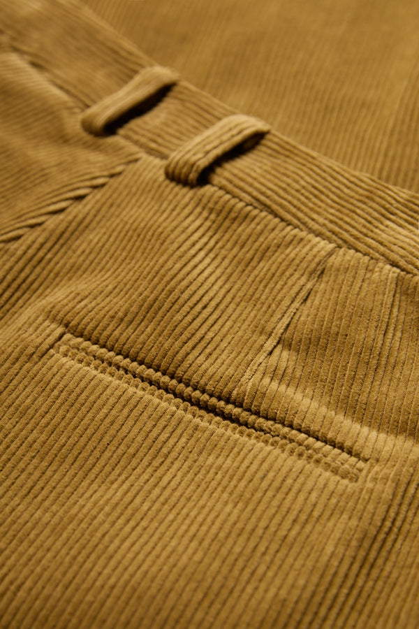 The Interim Pant corduroy fabric in Golden Tan with button-closing back pockets to keep valuables safe.