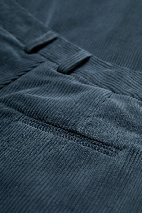 The Interim Pant corduroy fabric in Petrol Blue with button-closing back pockets to keep valuables safe.