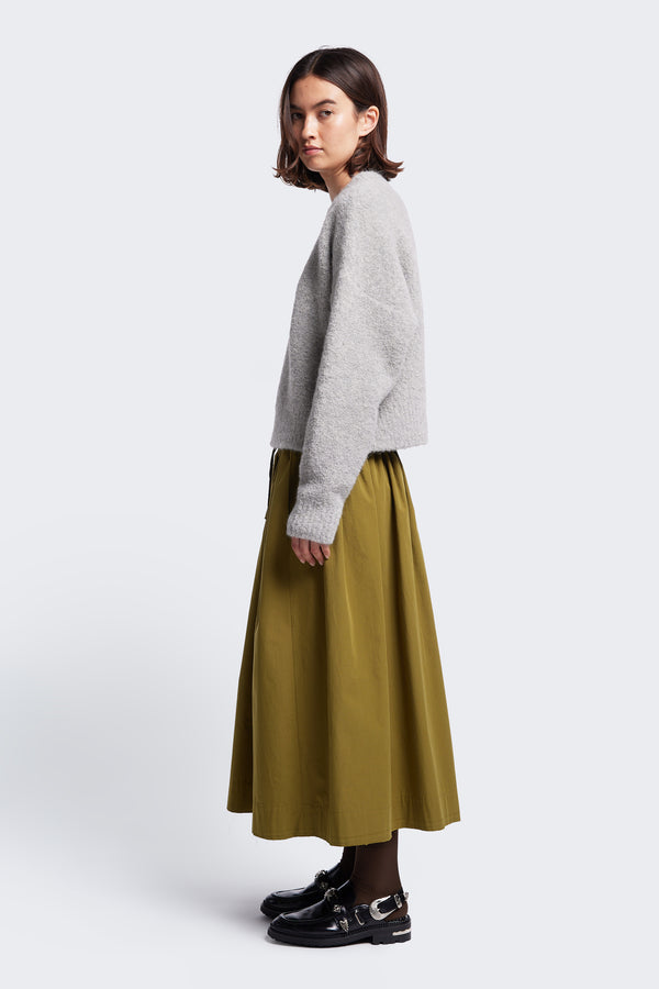 Side profile of Interlude Skirt in Moss Green. A comfortable skirt with an elasticated waistband and made from 100% cotton. 