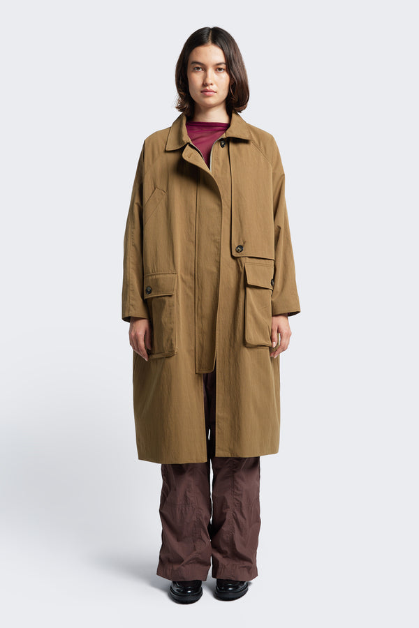 Model wears the Aegis Trench Coat Tan with round stand collar opened and the concealed centre front zip closed 