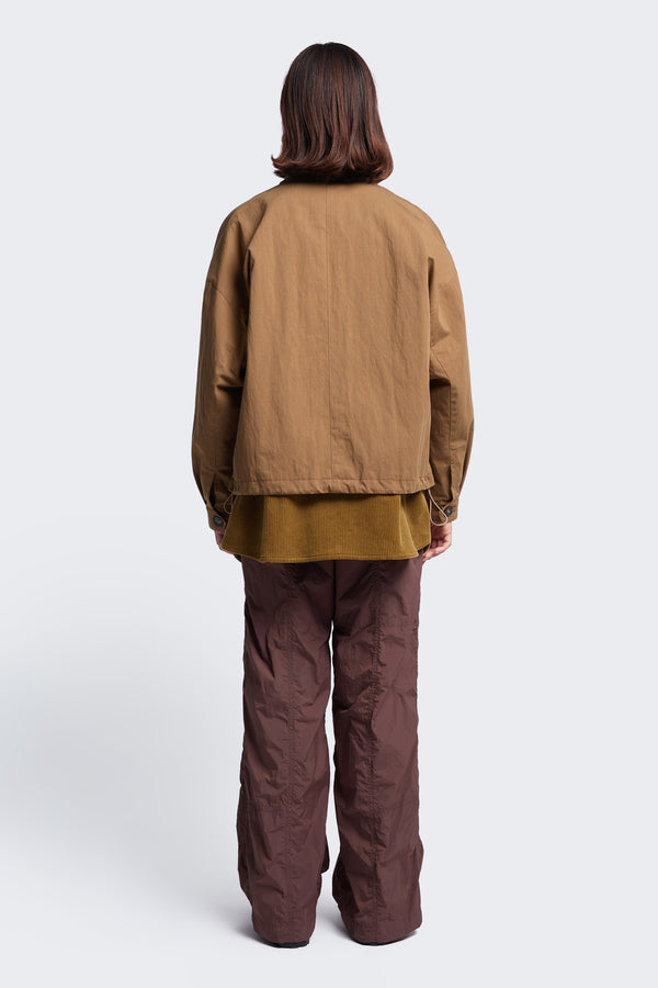 The back of the Embark Jacket Tan, a wide crop blouson style jacket with a boxy silhouette.