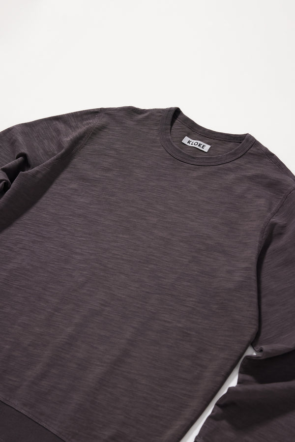 Close-up of the soft black pigment-dyed cotton fabric showing its subtle texture and worn-in character.