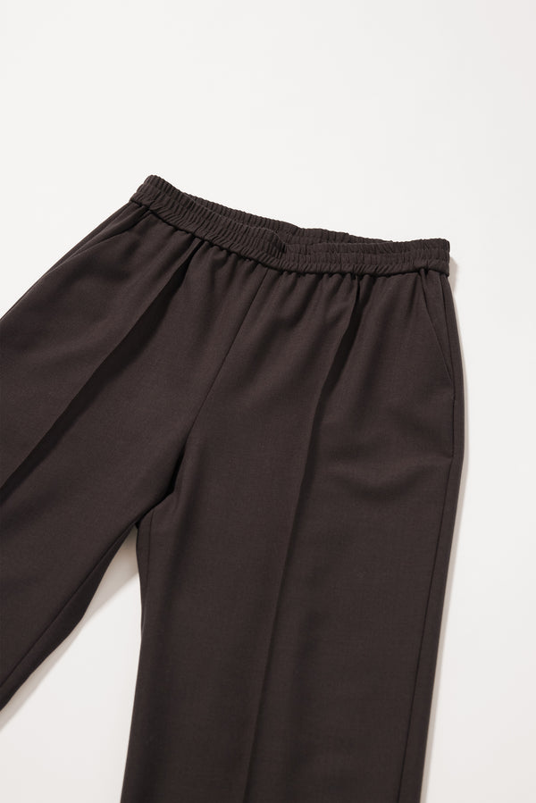 Close-up of the front pin tuck detailing on the dark taupe Manta Pant.