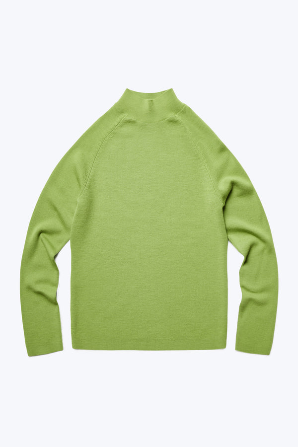 The front of Monument Mock Neck Sweater Apple Green. This slim fit sweater knitted in merino wool has a high neck. 