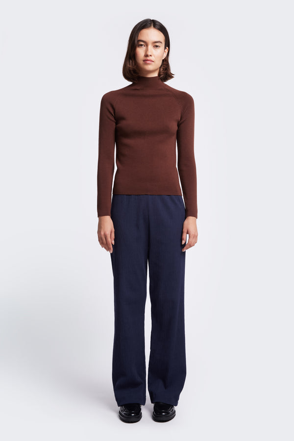 The Monument Mock Neck Sweater is a slim fit knit with a high neck and a 1 x 1 Rib Stitch. Knitted in a merino wool in Brown. Available in five sizes. 