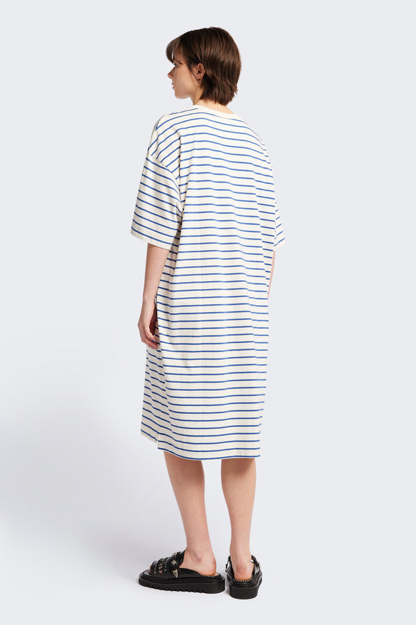 The back of the Nadir Dress, a laid-back style made from pure cotton jersey with blue and white stripes. This dress features side-splits, dropped shoulder, and elbow-grazing sleeves.