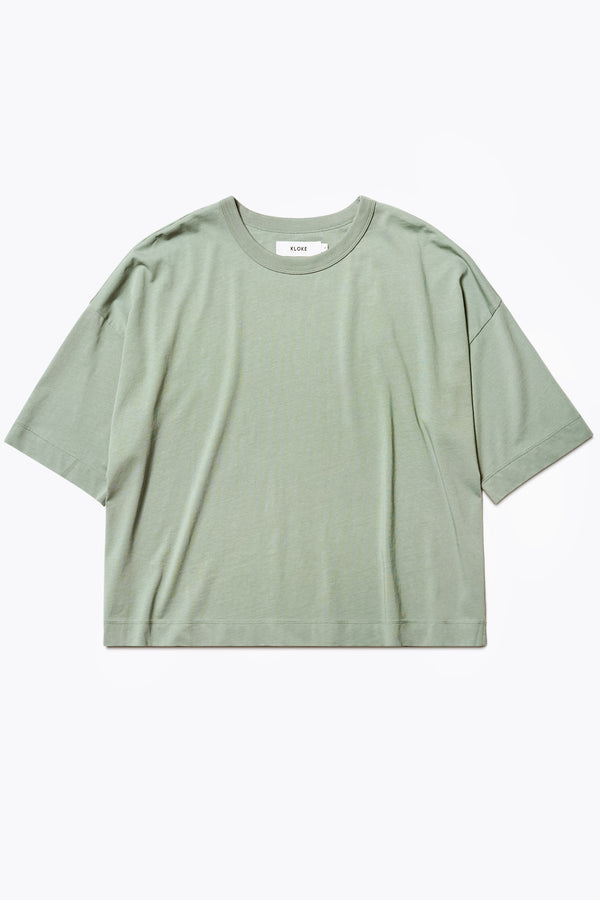 The Obelisk T-Shirt is a cropped oversize tee cut from high grad cotton in Sage. The t-shirt has an extra thick 1 x 1 rib bound cover stitched neckline, straight hem, and side-slit detail.