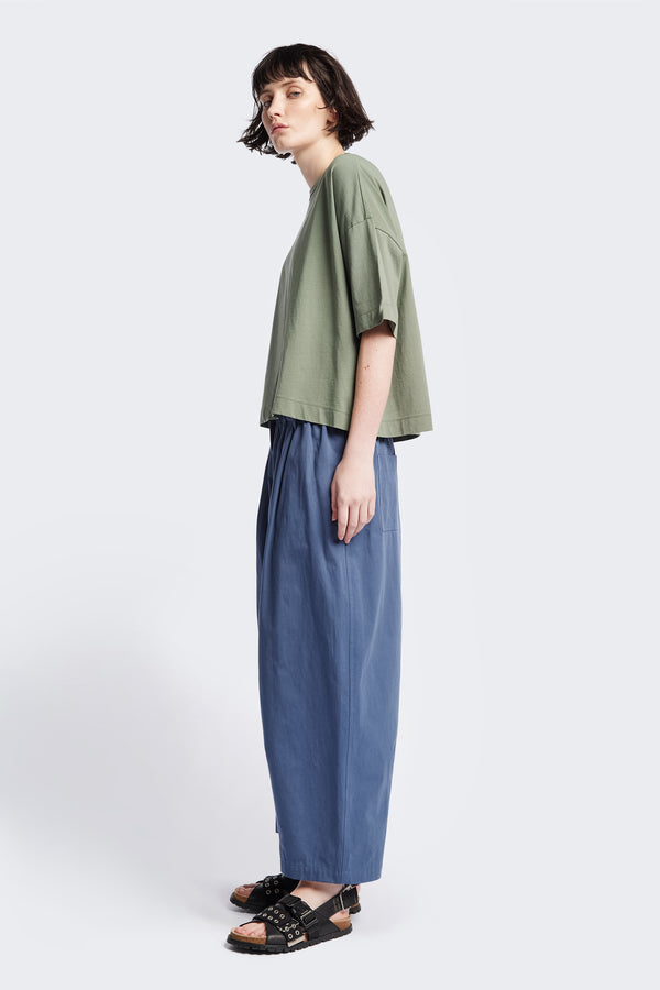 Side profile of the Obelisk T-Shirt Sage, a cropped oversize tee cut from high-grad cotton. 